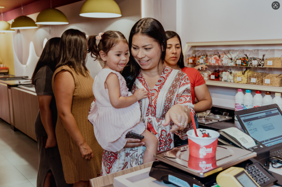 Mãe e filha pesando o sorvete de buffet de sorvetes em uma franquia sorveteria Geloni Sorvetes.